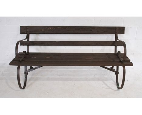 A wrought iron framed garden bench, with brown painted wooden slatted seat - length 152cm
