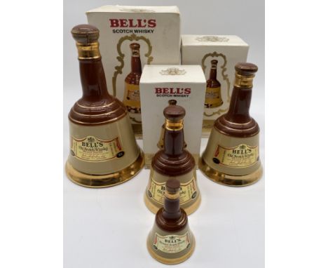A graduated set of three boxed Bell's 70% proof Scotch whisky each bottled in a Wade ceramic bell shaped decanter, ranging fr