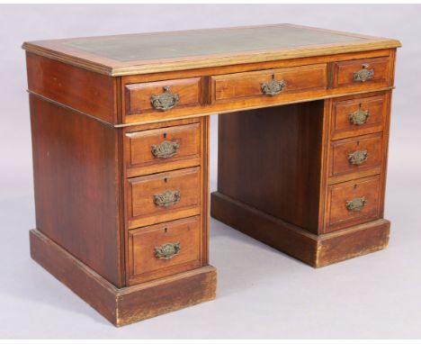 An Edwardian mahogany desk, first quarter 20th century, with tooled green leather writing surface above an arrangement of nin