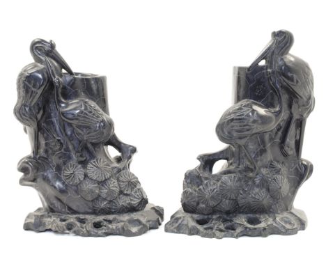 A pair of Japanese carved hardstone spill vases, 20th century, designed as hollow tree trunks with sprouting leaves, each wit