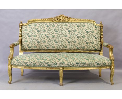 A French giltwood sofa, Louis XV style, 20th century, with cream ground upholstery with green floral design, raised on cabrio