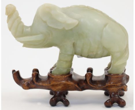 A Chinese hardstone elephant, 20th century, naturalistically carved with the trunk raised, the stone of pale celadon tone wit