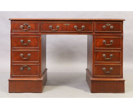 An English mahogany pedestal desk, 20th century, with tooled green leather writing surface above an arrangement of eight draw