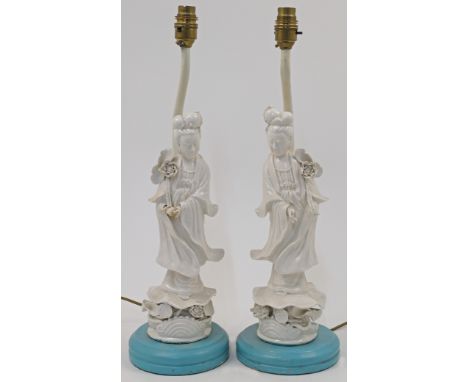 A pair of Blanc de Chine table lamps, 20th century, each designed as a figure of Guanyin atop a blue painted wood base with l