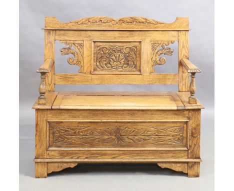 A carved oak box seat settle, second quarter 20th century, 97cm high, 106cm wide, 40cm deepCondition Report:  light scratches