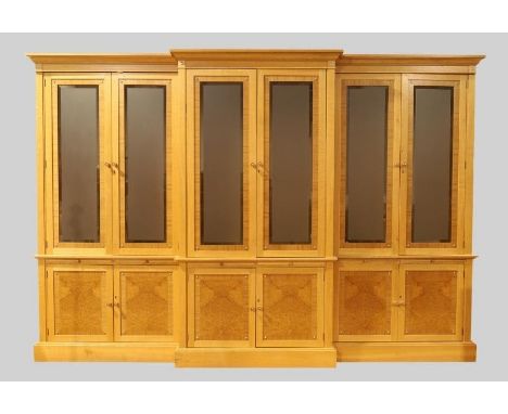 In the manner of David Linley, a bespoke light oak and burl wood breakfront library bookcase, 21st century, the moulded stepp
