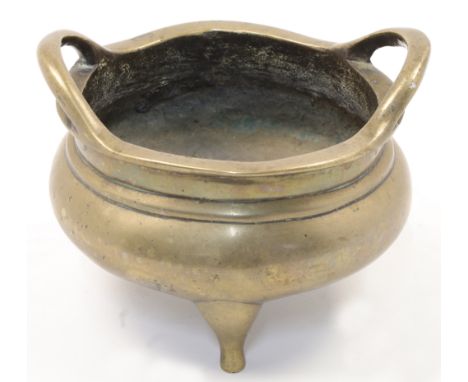A Chinese bronze censer, 19th century, cast in circular form with twin high loop handles and three feet, apocryphal Xuande ca