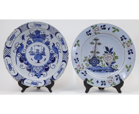 An English delftware plate, 18th century, decorated in blue, red, green and yellow with flowers sprouting from rock to the ce