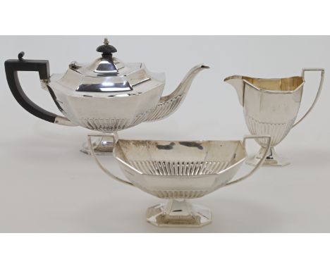 A silver three-piece tea set, Sheffield, 1923, maker HLB, comprising: a teapot with ebonised handle and finial, a milk jug an