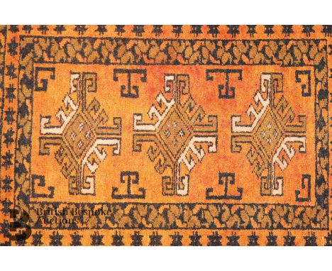 A 20th century Turkish wool carpet, ochre and black colouring, approx 100 x 150 cms, selvedges complete with trimmed tassels.