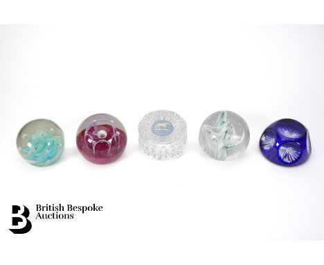 Thirteen 20th century glass paperweights, various designs, including a cobalt blue faceted paperweight, Flying fish over swir