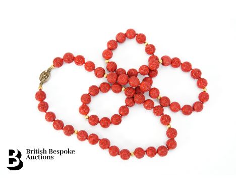 A string of Chinese red beads, carved with Chinese character interspersed with gold coloured beads and a silver clasp, approx
