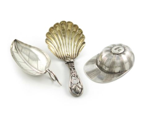 A small collection of three silver caddy spoons, comprising: one modelled as a jockey's cap, by the Goldsmiths and Silversmit