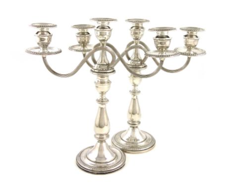 A pair of American silver three-light candelabra, baluster columns, reeded scroll handles, urn shaped capitals, gadroon borde