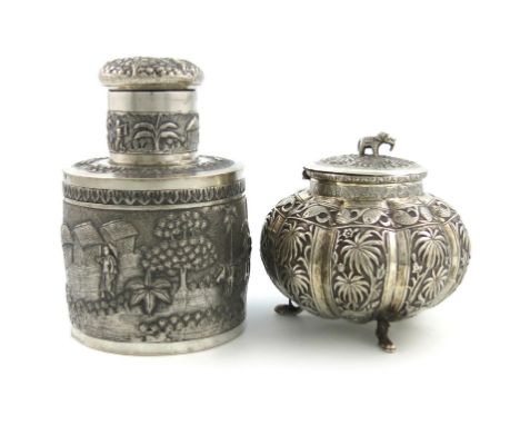 An Indian silver tea caddy, possibly Calcutta, cylindrical form, with village scenes, screw-off cover, height 14.5cm, plus an