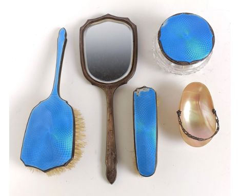 A George V silver and blue enamel hand mirror, two matching brushes, a cut glass vase with silver lid, and a shell with a whi