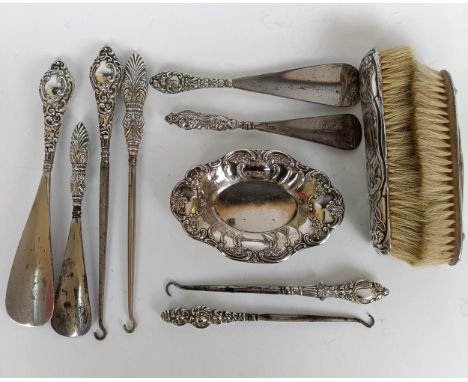 Two matching pairs of silver handled button hooks and shoehorns, other Art Nouveau brushes and a silver dish (11)