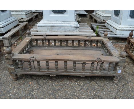 An Indian hardwood rectangular cradle or plant trough with turned spindle supports.