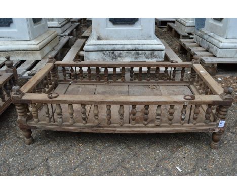 An Indian hardwood rectangular cradle or plant trough with turned spindle supports.