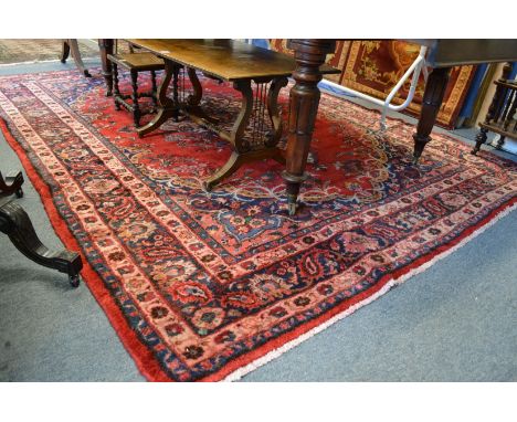 A Persian style carpet, red ground with floral decoration 295cms x 215cms.