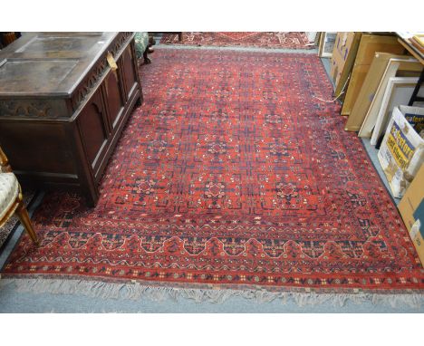 A Persian carpet, red ground with stylized decoration 295cms x 195cms.