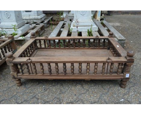 An Indian hardwood rectangular cradle or plant trough with turned spindle supports.