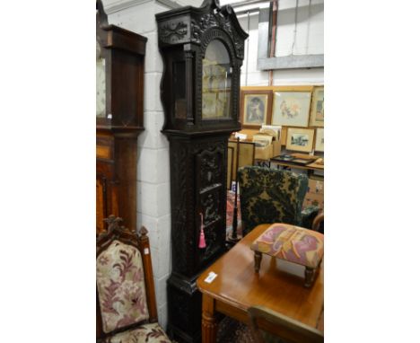 A 19th century carved oak longcase clock with engraved brass arched dial, eight-day movement.