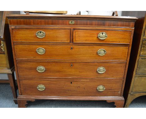 A George III mahogany chest with a narrow frieze drawer above two short and three long drawers on bracket feet.