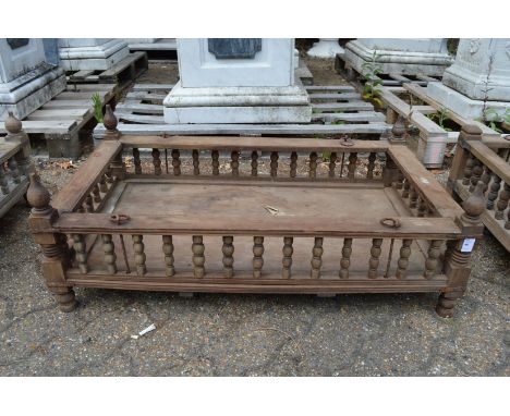 An Indian hardwood rectangular cradle or plant trough with turned spindle supports.