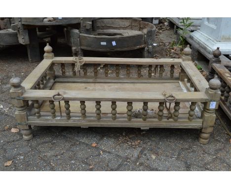 An Indian hardwood rectangular cradle or plant trough with turned spindle supports.