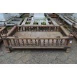 An Indian hardwood rectangular cradle or plant trough with turned spindle supports.