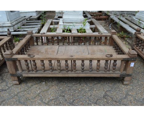 An Indian hardwood rectangular cradle or plant trough with turned spindle supports.