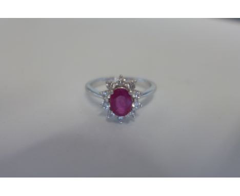 An 18ct white gold, ruby and diamond ring, natural genuine ruby -  6.95mm in length and 5.04mm wide, oval shape facet cut - t