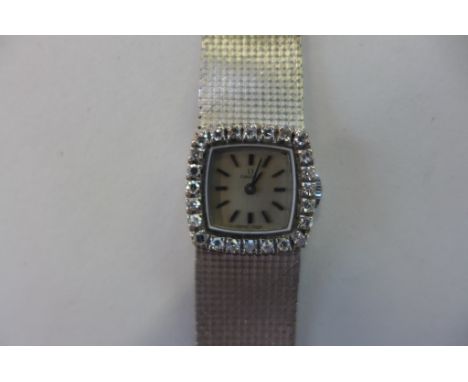 A ladies vintage 18ct white gold Omega diamond encrusted manual wind wristwatch, the square dial surrounded by 24 diamonds, a