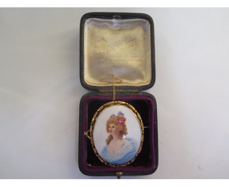 A portrait miniature of a lady set in 9ct yellow gold mount and safety chain, in good condition 