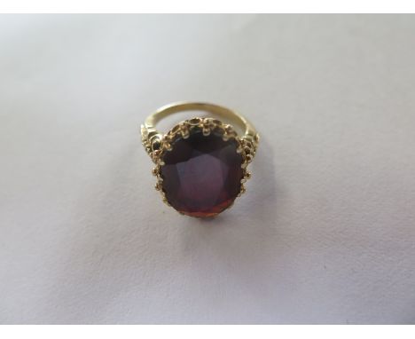 A 9ct gold dress ring with large garnet coloured stone, size M, approx 6.8 grams, in good condition 