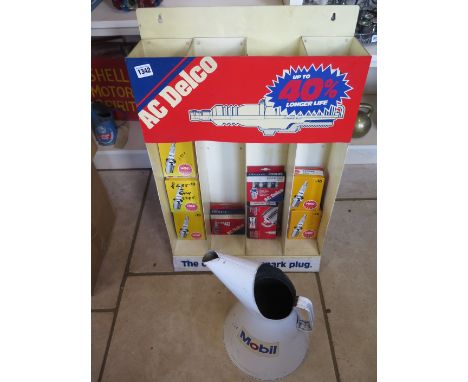 An AC Delco motoring spark plug stand and contents and a Mobil Oil pourer 