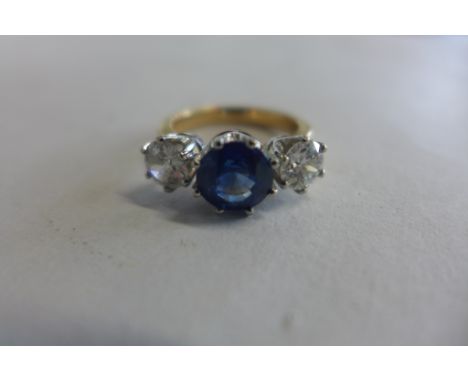 An 18ct gold and platinum sapphire and diamond three stone ring, the central stone a peacock blue Ceylon sapphire, approx 2ct