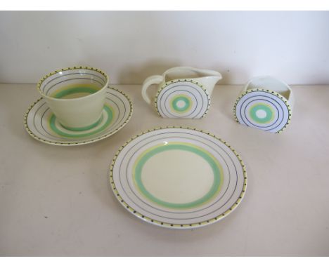 A Clarice Cliff tea cup, saucer, tea plate, sugar bowl and milk jug, with green and yellow rounded design, some crazing but o