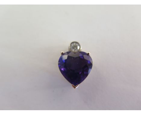 An 18ct amethyst and diamond heart through pendant, 15mm x 10mm - in good condition 