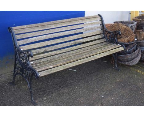 A cast iron and slatted wood garden bench