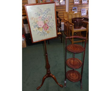 A mahogany Pole Screen with adjustable tapestry banner on triple splay supports and an oak three tier folding cake stand. 