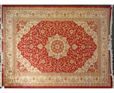 A Keshan pattern Carpet with a centre medallion on a red field and bordered, 9' 2" (280cms) x 6' 6" (200cms).
