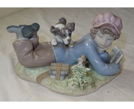 Another Lladro Figure of a boy reading a book and playing with a puppy.
