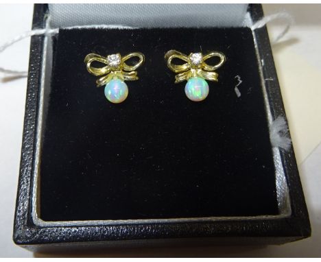 A pair of silver gilt tied bow design Earrings set with a single opal. 