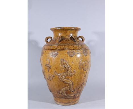 Large Chinese Brown-Glazed Dragon Martaban Storage Jar. China or Southeast Asia. The rounded sides molded with dragons and cr