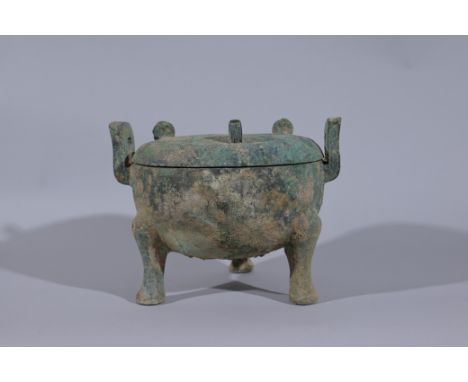 Archaic Bronze Ritual Food Vessel, Ding.The vessel of globular form, supported by three legs, the shoulder with two upright r