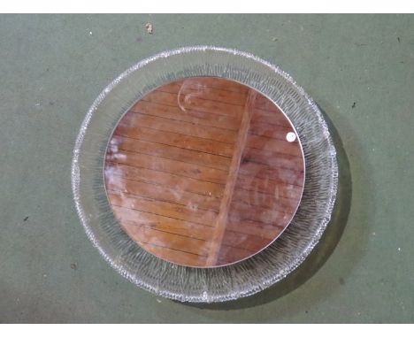 A circular mirror light with textured lucite frame 