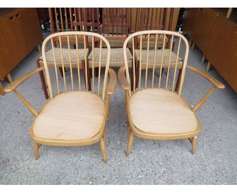A pair of Ercol lounge chairs in light elm