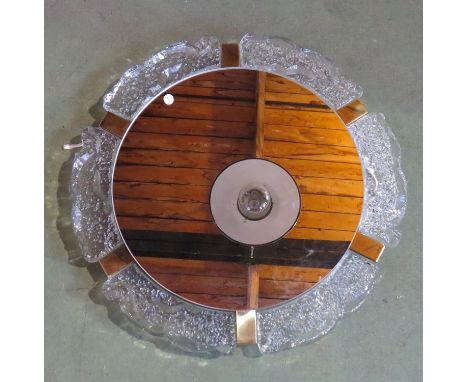 A illuminating circular wall mirror with textured glass surround 
